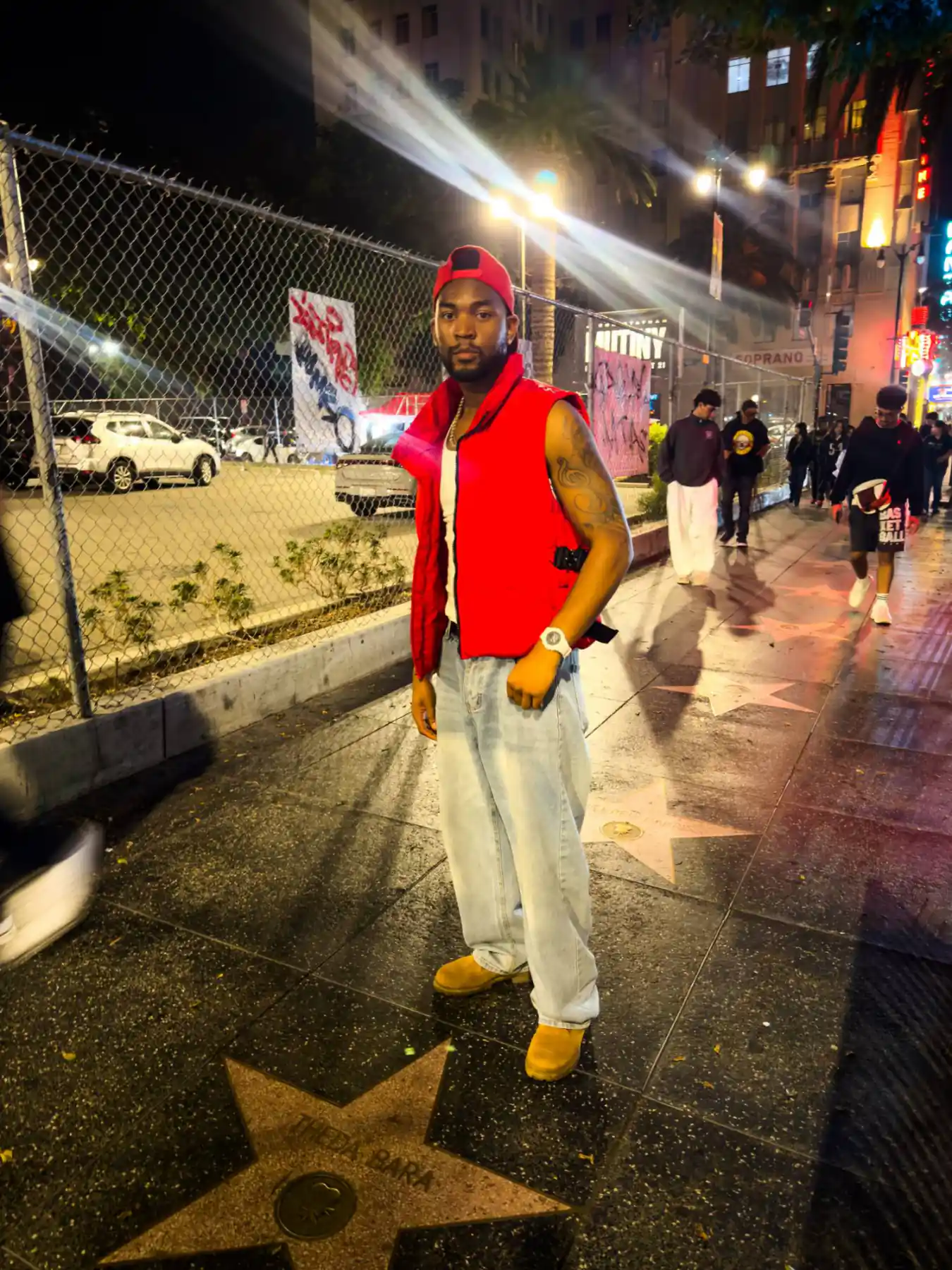 Bren Got Hits in a red puffer vest on the Hollywood Walk of Fame at night